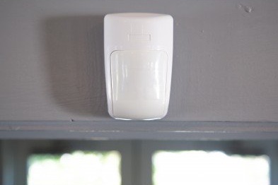 Motion sensor installed on a wall over a door